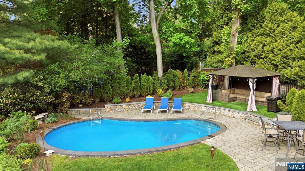 203 Heights Road Ridgewood, NJ 07450 - Photo 36 of 41 a view of pool with table and chairs under an umbrella