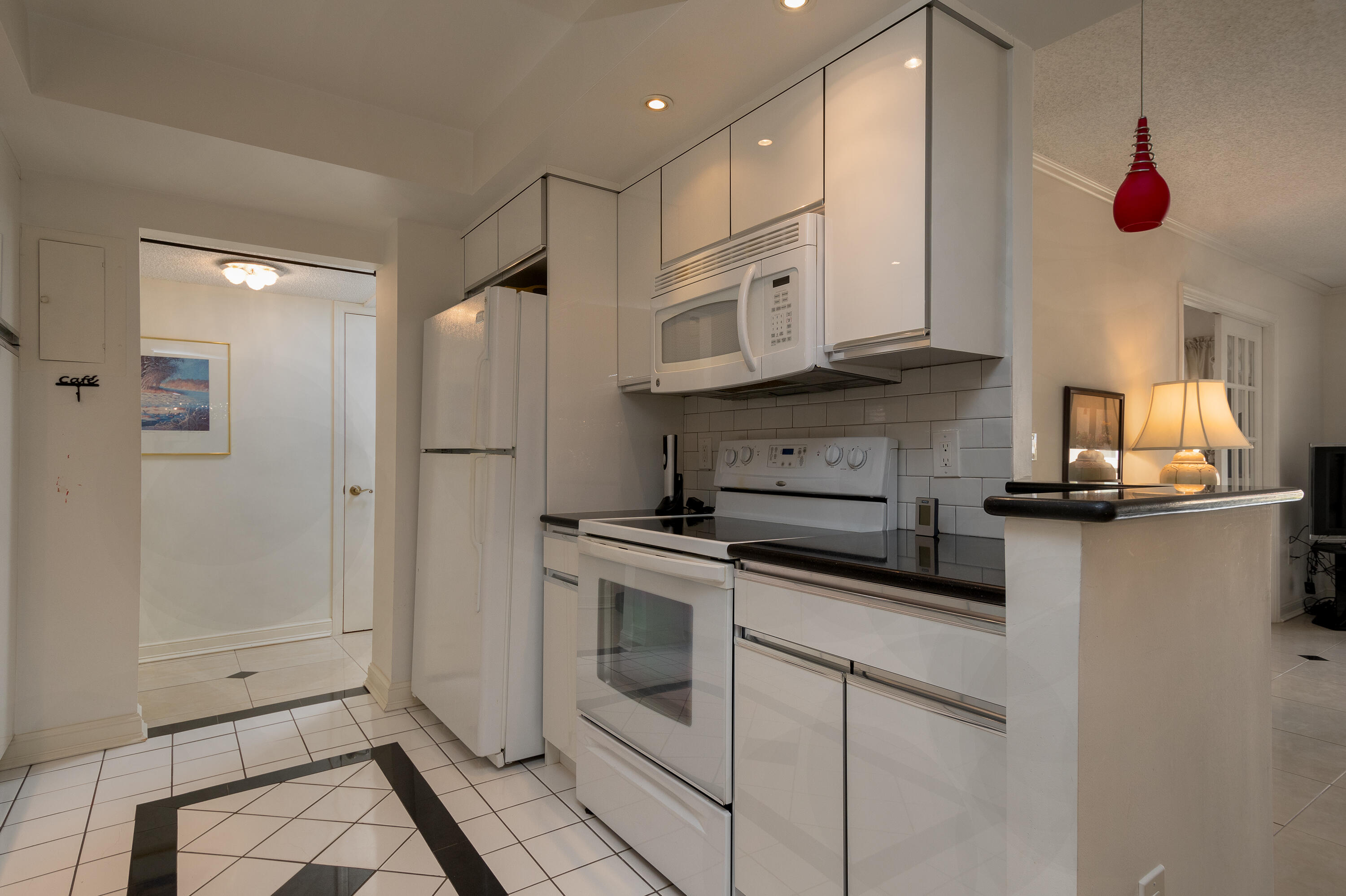 951 De Soto Road, Unit 427 Boca Raton, FL 33432 - Photo 16 of 44 a kitchen with stainless steel appliances granite countertop a refrigerator a oven and white cabinets with wooden floor