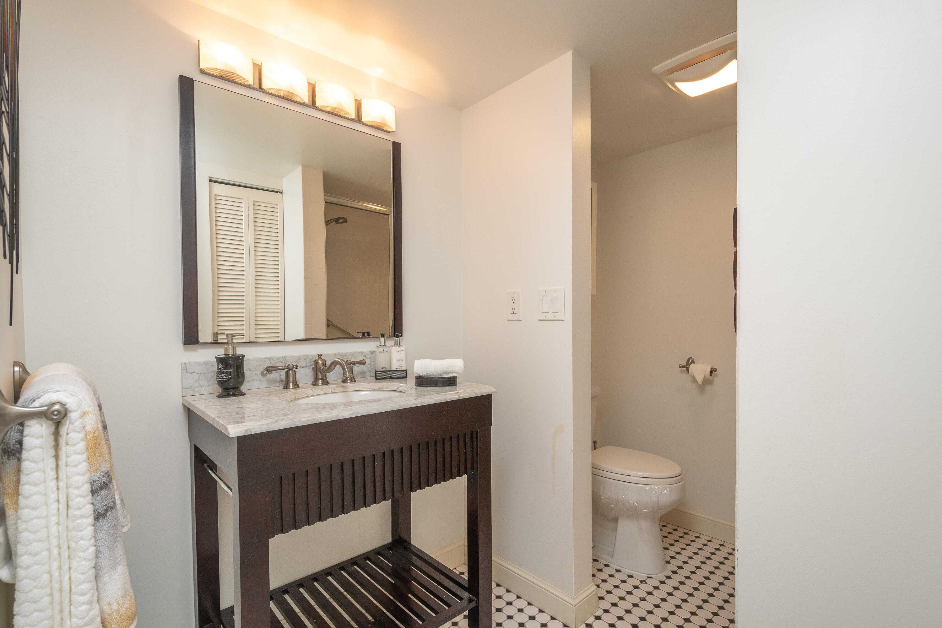 951 De Soto Road, Unit 427 Boca Raton, FL 33432 - Photo 19 of 44 a bathroom with a sink toilet a mirror and vanity
