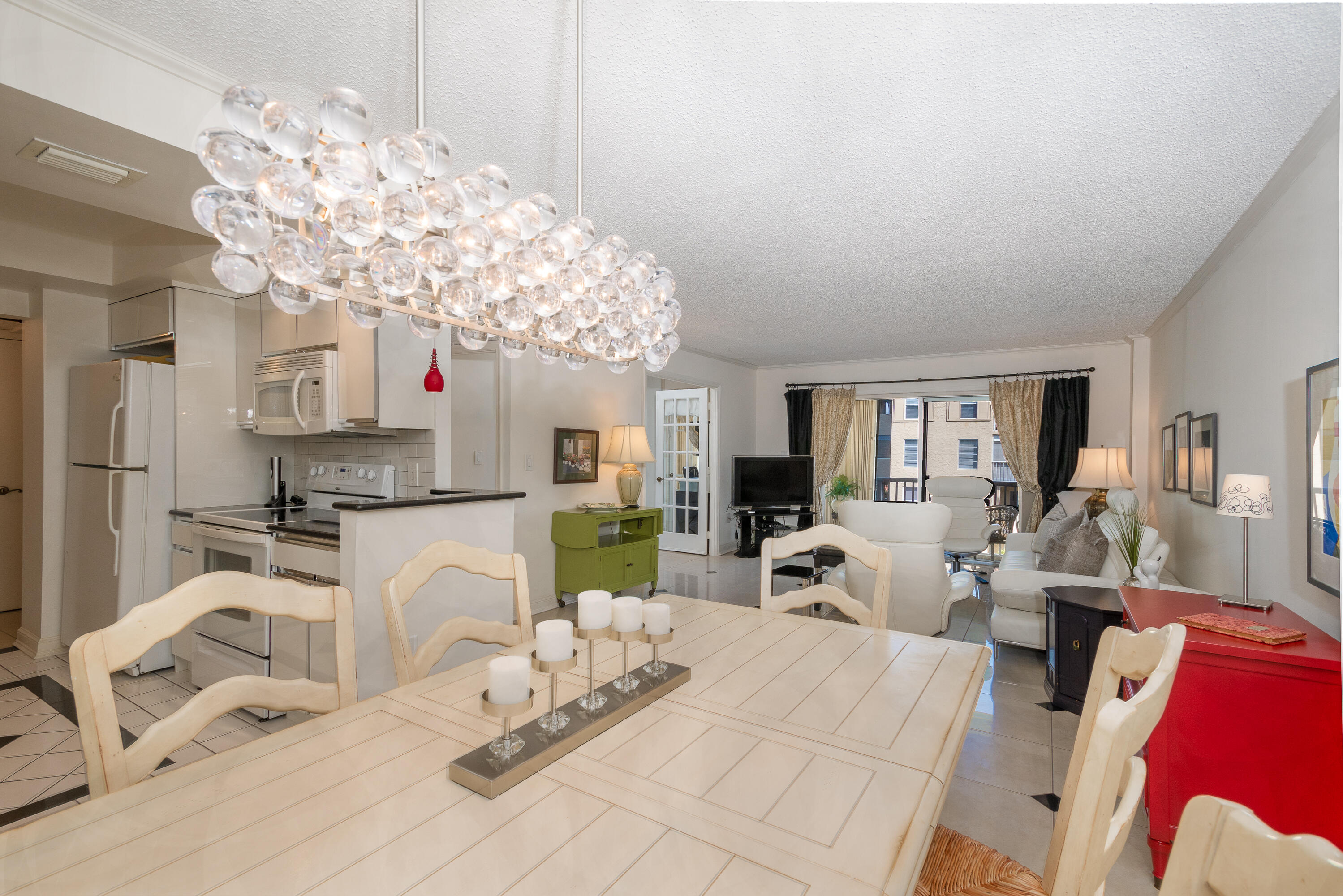 951 De Soto Road, Unit 427 Boca Raton, FL 33432 - Photo 7 of 44 a living room with furniture a chandelier and a flat screen tv