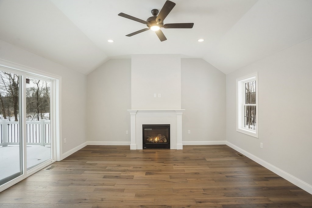 182 Davis Road Westminster, MA 01473 - Photo 20 of 42 an empty room with wooden floor fireplace and windows