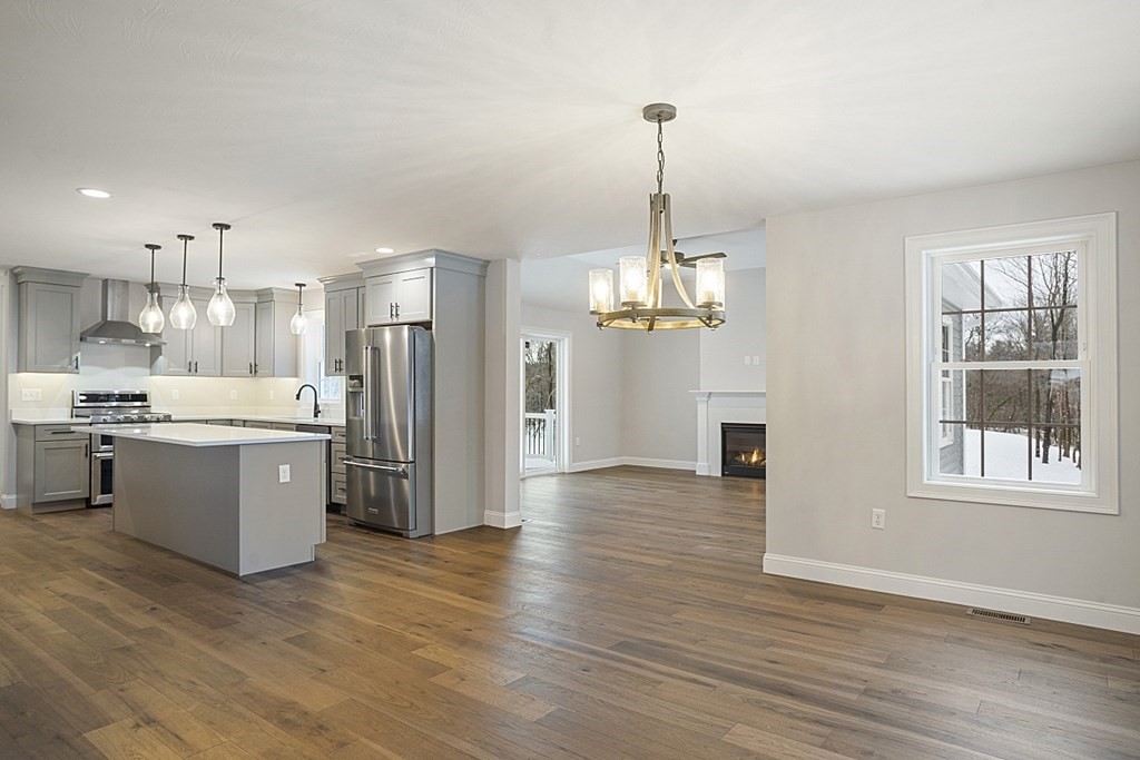 182 Davis Road Westminster, MA 01473 - Photo 8 of 42 a large kitchen with a refrigerator a sink dishwasher a dining table and chairs with wooden floor