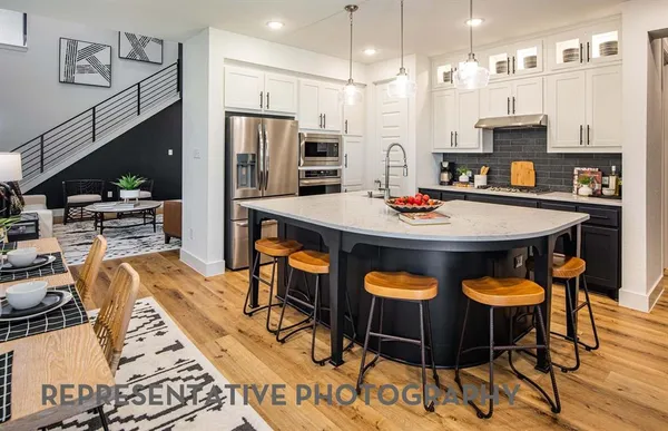 a kitchen with stainless steel appliances granite countertop a stove a sink and a refrigerator