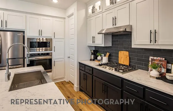 a kitchen with granite countertop a refrigerator stove and sink
