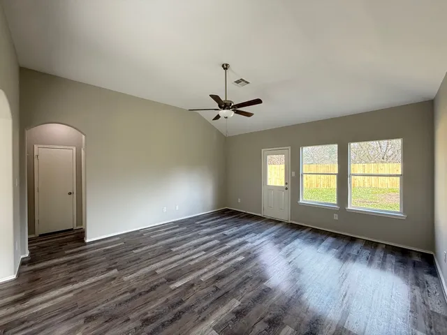 a view of a livingroom with wooden floor and a ceiling fan
