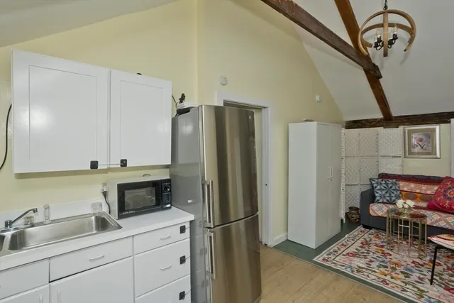 a bedroom with a bed and a view of kitchen