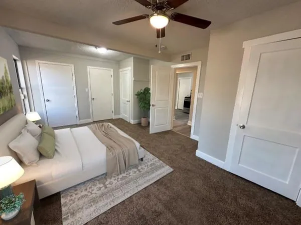 a spacious bedroom with a bed and a chandelier