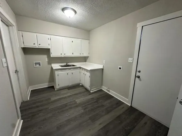 a kitchen with a sink and wooden floor