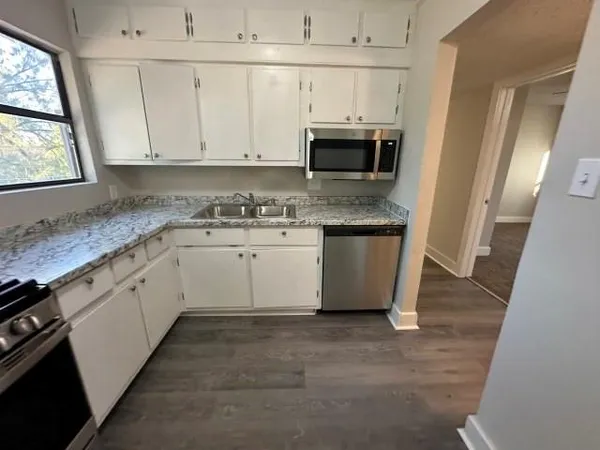 a kitchen with stainless steel appliances granite countertop a stove a sink and a microwave