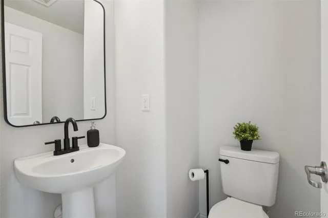 a bathroom with a sink mirror and toilet