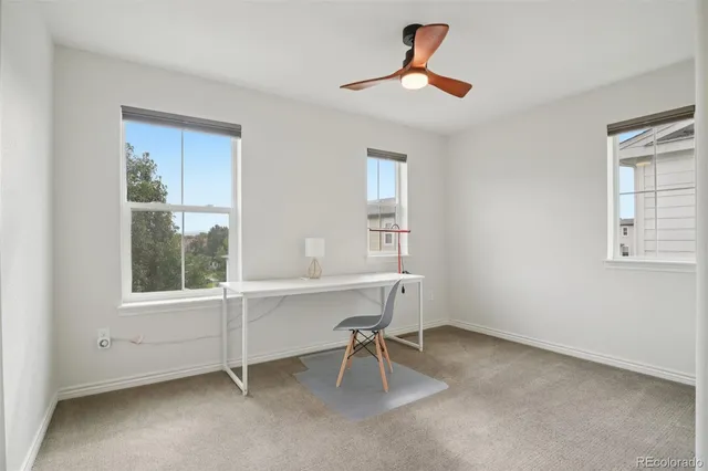a view of a workspace with furniture and a window