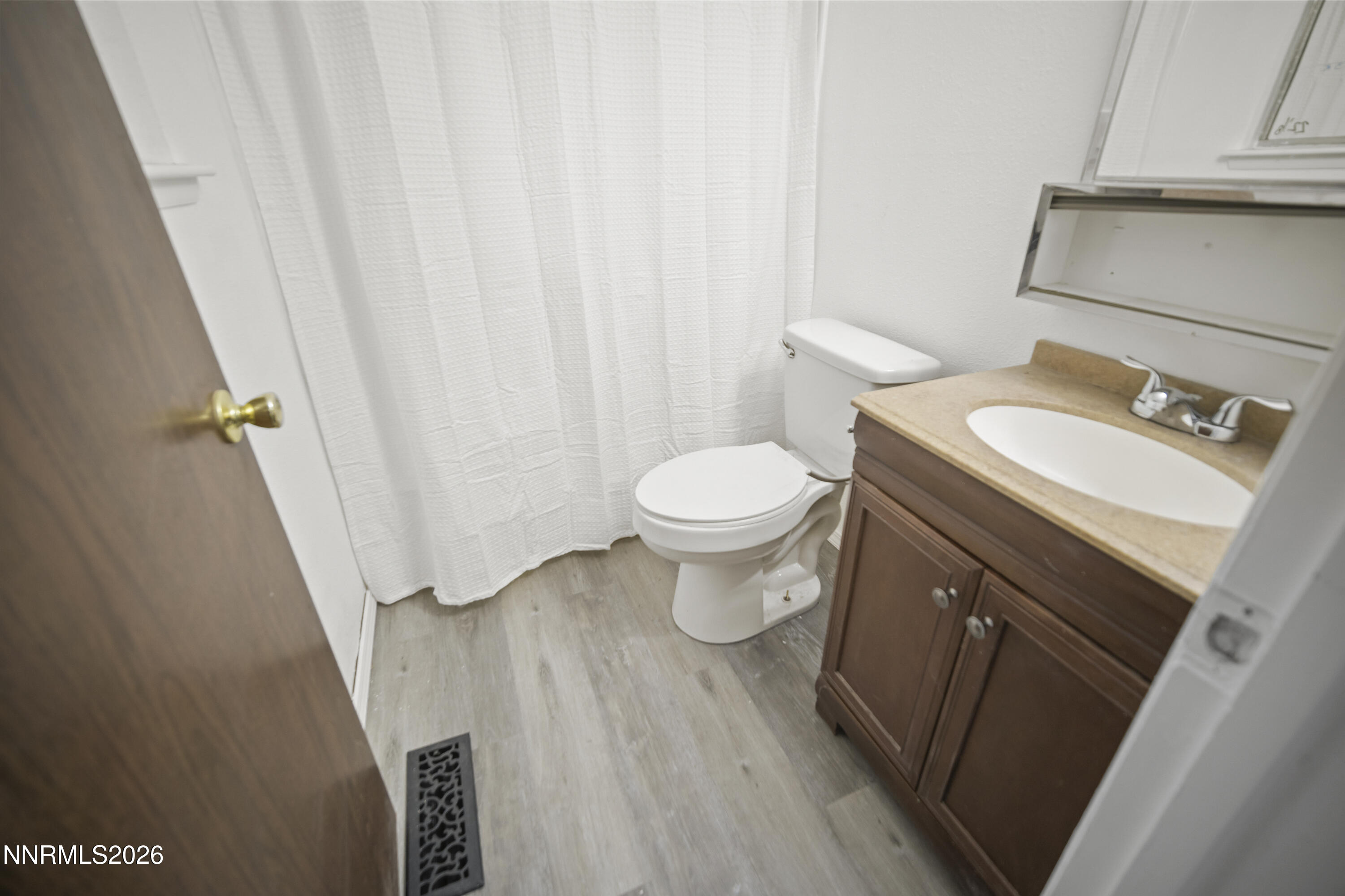 150 McCart Street Fernley, NV 89408 - Photo 24 of 28 a bathroom with a sink a toilet and shower curtain