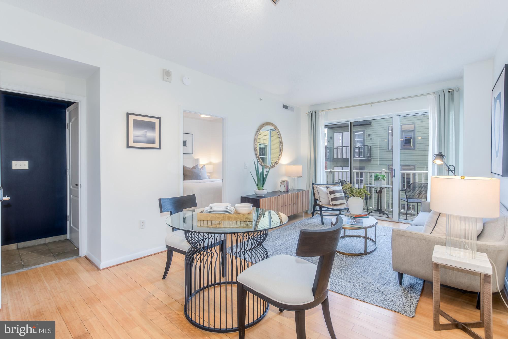 1111 11th Street Northwest, Unit 309 Washington, DC 20001 - Photo 3 of 18 a living room with furniture a table and a large window