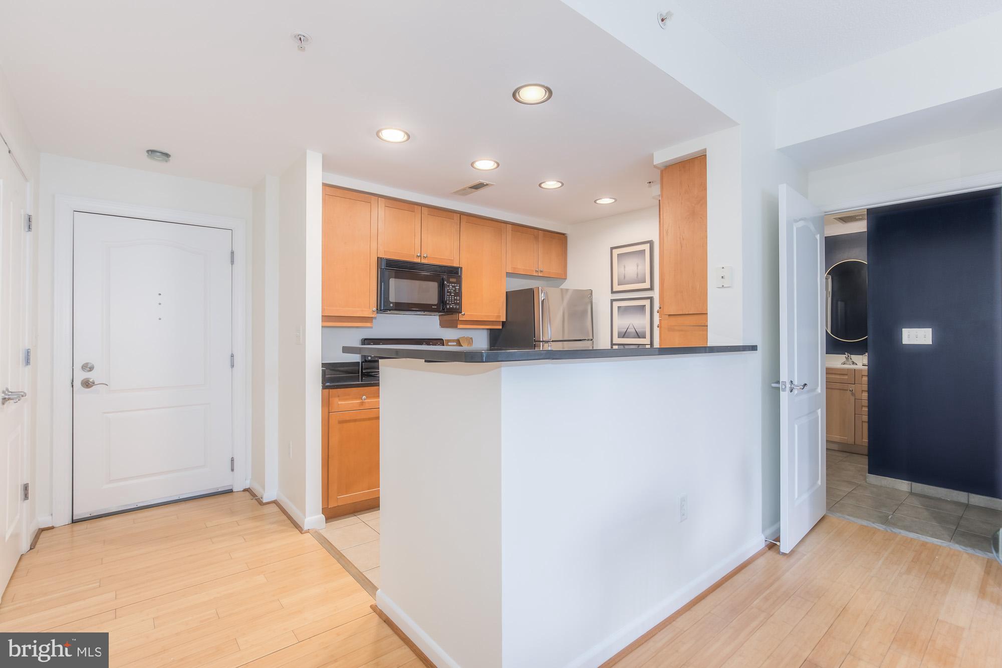 1111 11th Street Northwest, Unit 309 Washington, DC 20001 - Photo 6 of 18 a view of kitchen with kitchen island granite countertop refrigerator and a sink