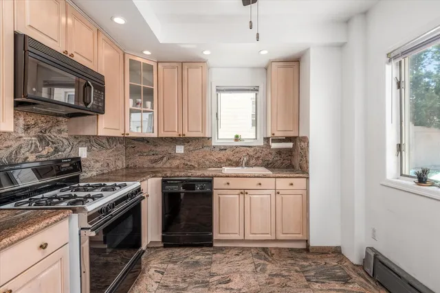 a kitchen with stainless steel appliances granite countertop a stove top oven a sink dishwasher a dining table and chairs with wooden floor