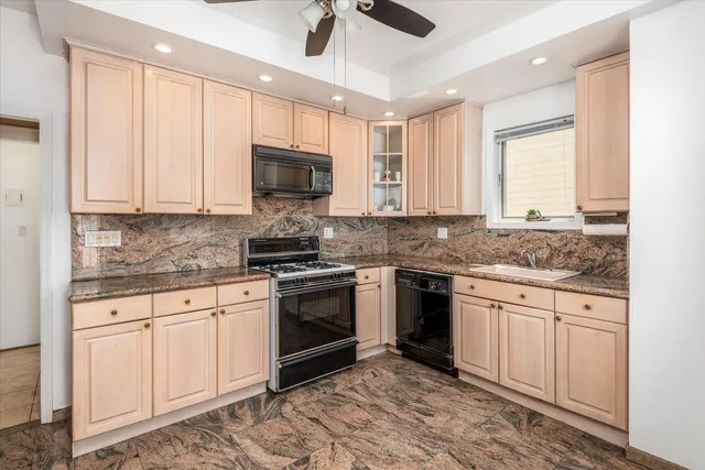 a kitchen with granite countertop a stove sink and microwave