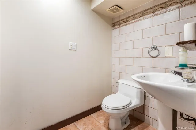 a white toilet sitting next to a white sink and vanity