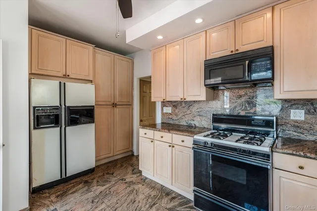 a kitchen with stainless steel appliances granite countertop a refrigerator stove and microwave