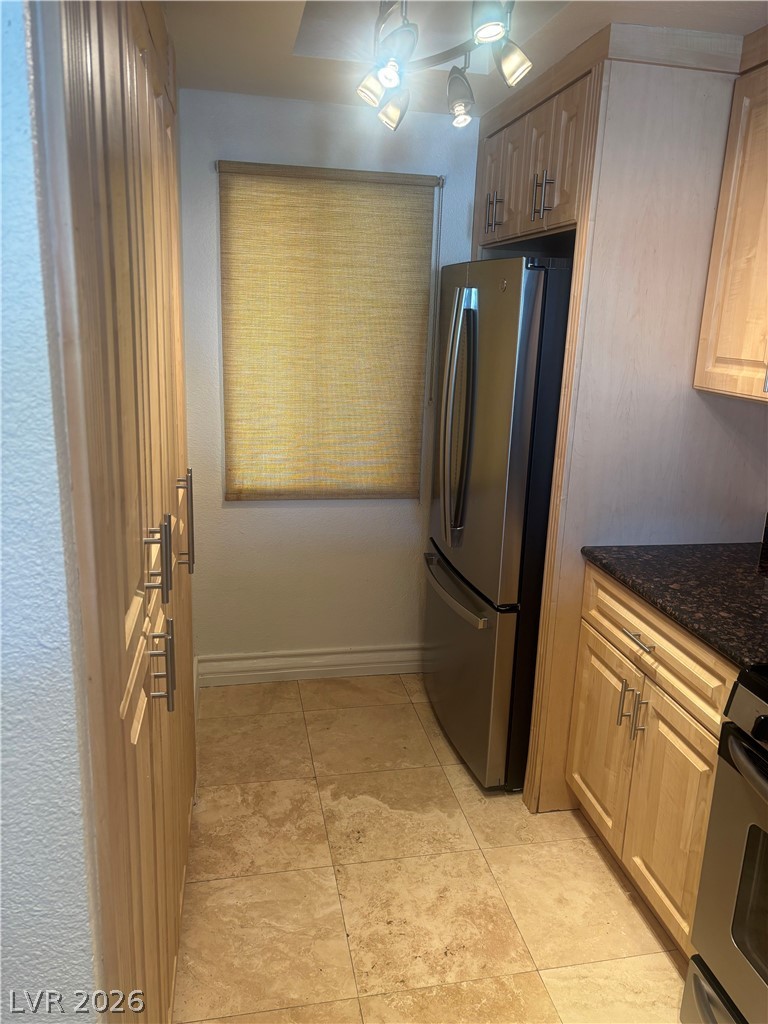 210 East Flamingo Road, Unit 123 Las Vegas, NV 89169 - Photo 7 of 17 Richly toned stone countertops and light wood cabinetry define this functional kitchen workspace.