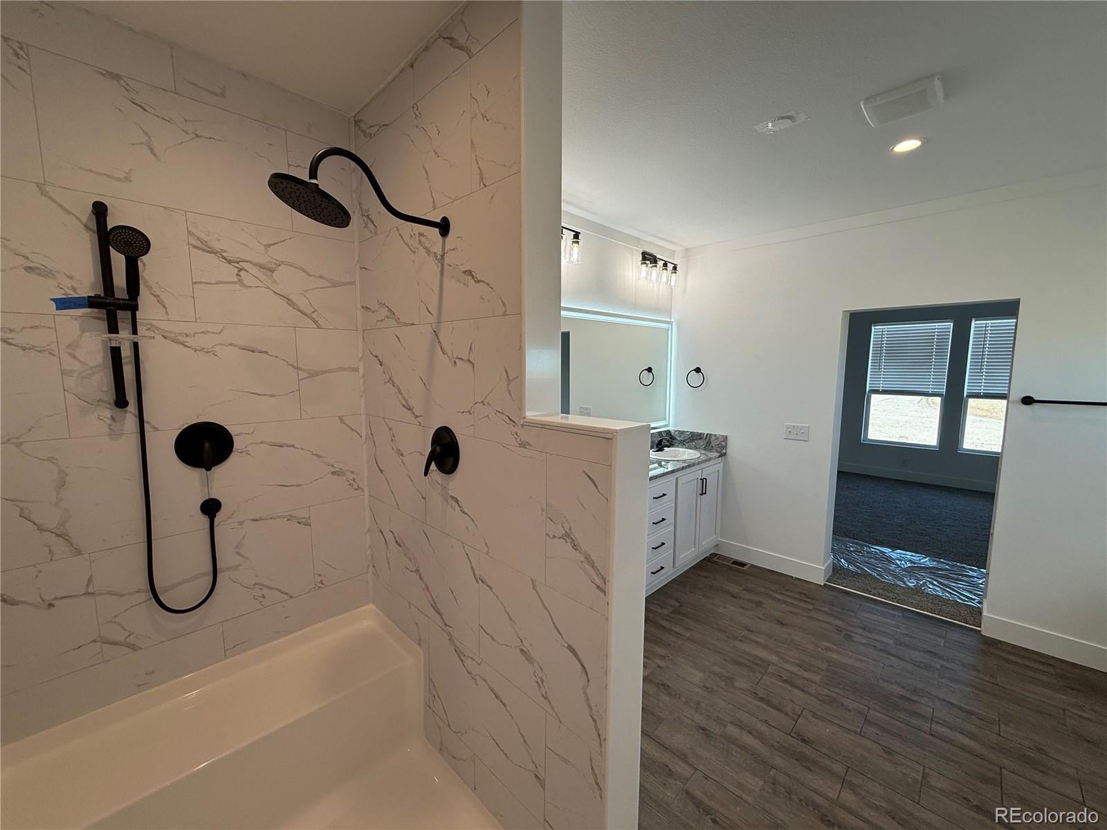 5165 Pass Me By Road Strasburg, CO 80136 - Photo 19 of 24 a bathroom with a granite countertop sink a toilet and shower