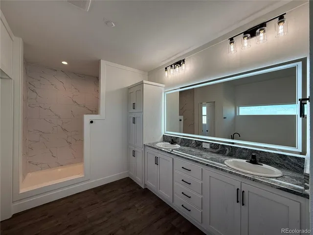 a spacious bathroom with a granite countertop sink and mirror
