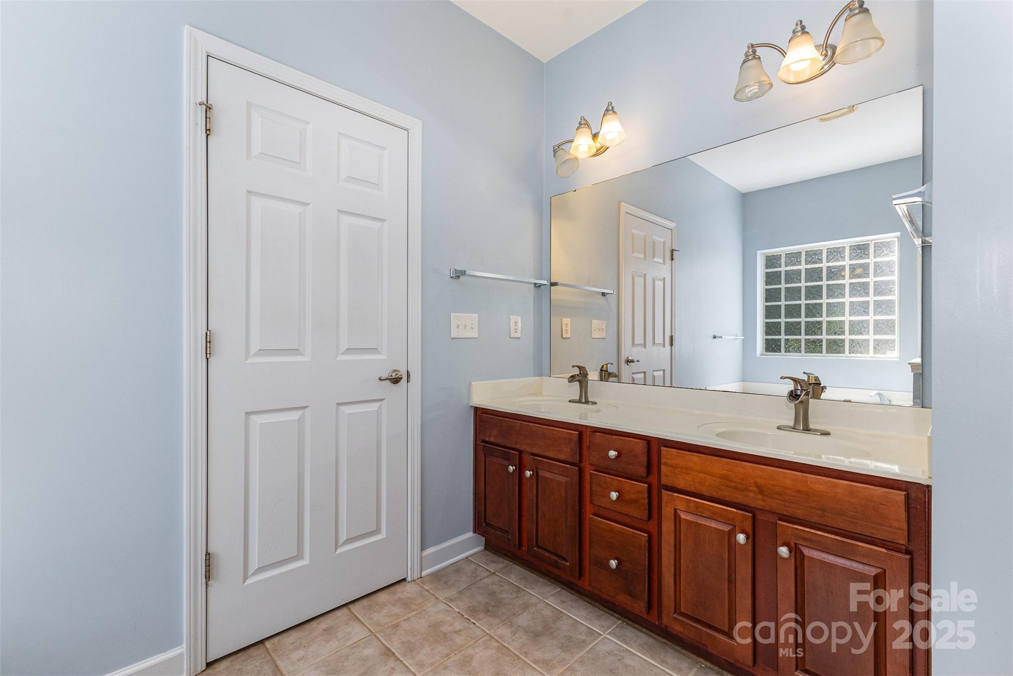 445 Buttermere Road Fort Mill, SC 29715 - Photo 14 of 42 a spacious bathroom with double vanity sink a window and a mirror