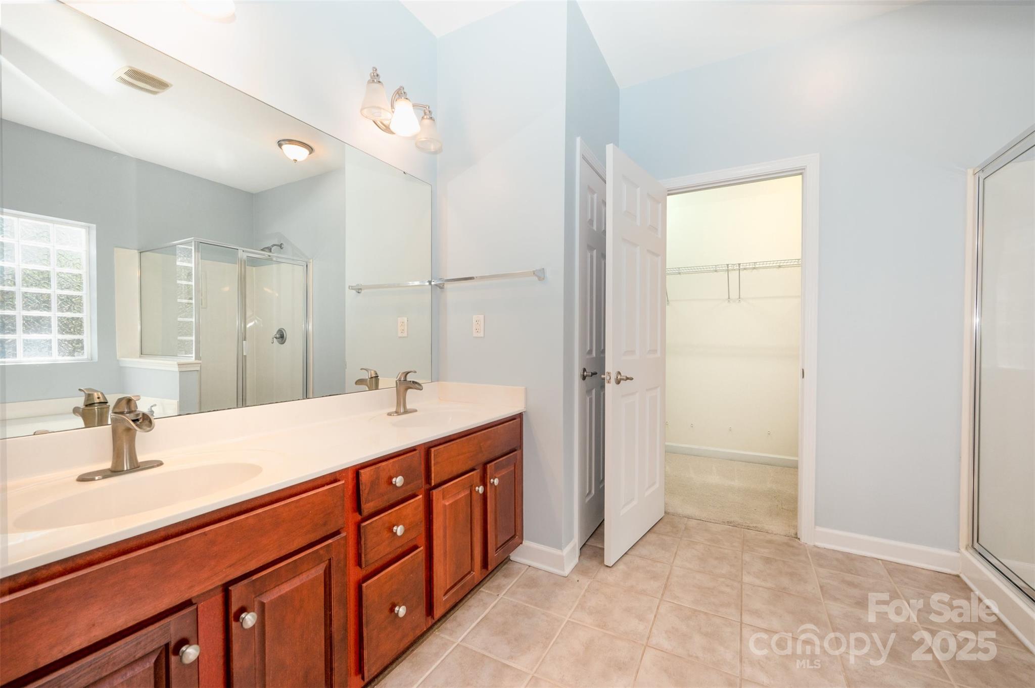 445 Buttermere Road Fort Mill, SC 29715 - Photo 14 of 35 a bathroom with a double vanity sink a mirror and a bathtub