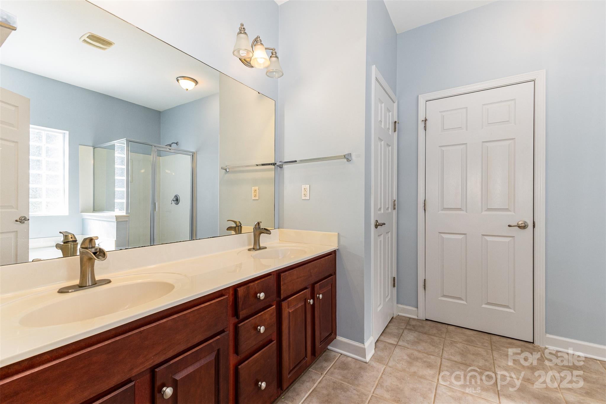 445 Buttermere Road Fort Mill, SC 29715 - Photo 15 of 42 a spacious bathroom with a double vanity sink a mirror and shower