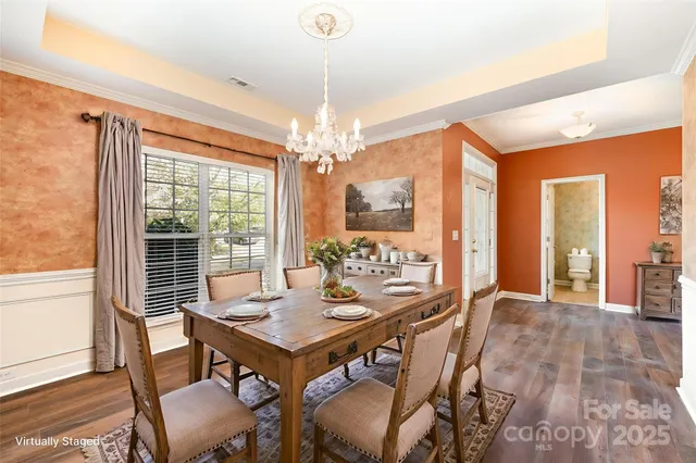a dining room with furniture a chandelier and wooden floor