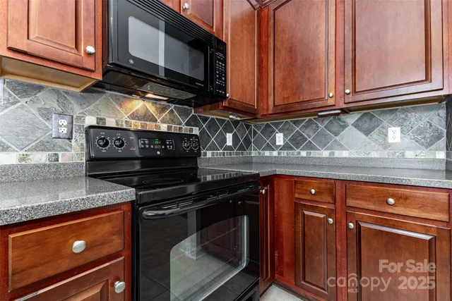 a kitchen with stainless steel appliances granite countertop a stove microwave and cabinets