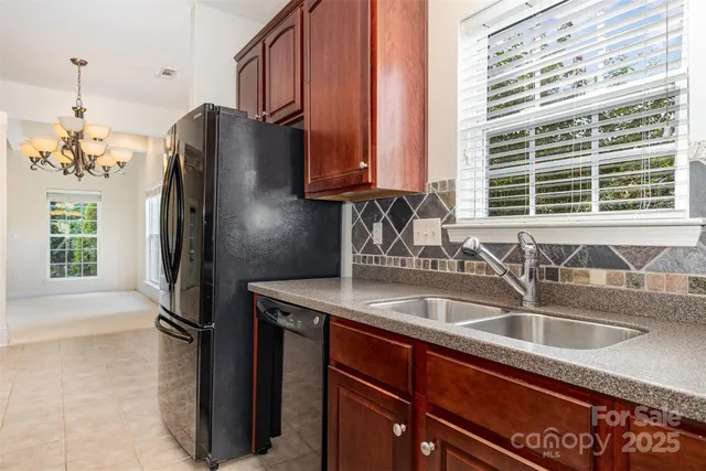 a kitchen with stainless steel appliances granite countertop a sink refrigerator and microwave
