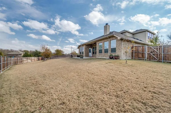 a view of a house with a yard and fence