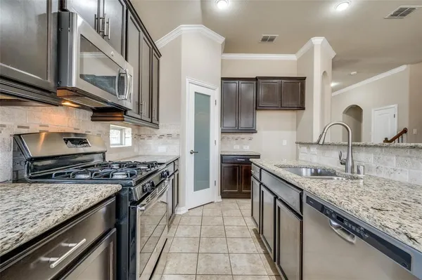 a kitchen with stainless steel appliances granite countertop a sink stove and cabinets