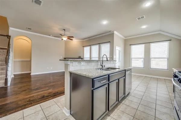 a large kitchen with granite countertop a stove and a sink
