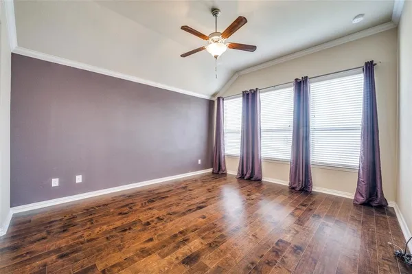 an empty room with wooden floor and window