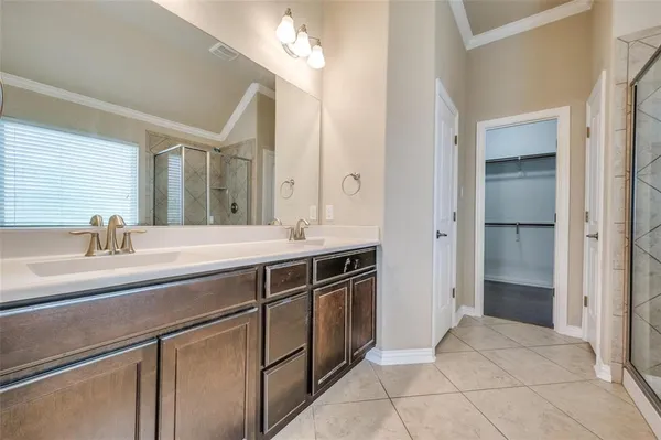 a spacious bathroom with a double vanity sink a mirror and a shower