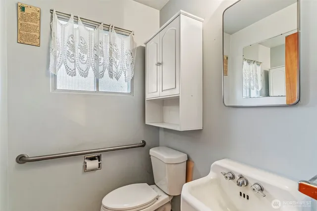 a bathroom with a toilet sink and mirror