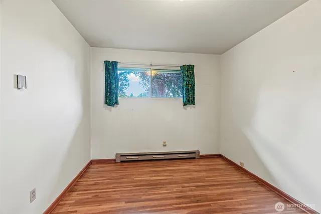 a view of a room with wooden floor and white walls