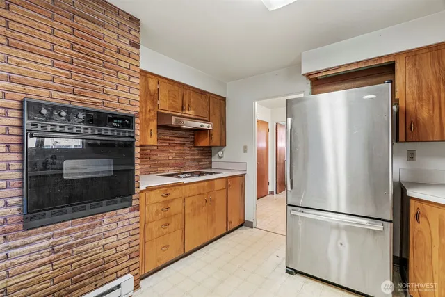 a kitchen with stainless steel appliances granite countertop a refrigerator a stove a sink and a microwave