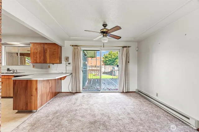 a view of a kitchen with granite countertop a stove top oven a sink with wooden cabinets and glass door