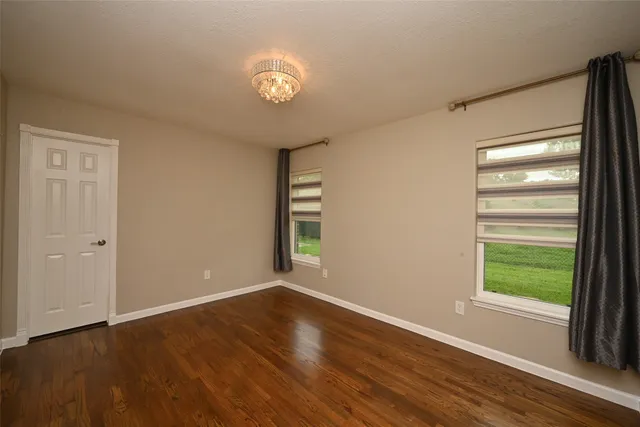 a bathroom with a granite countertop sink a toilet a mirror and shower