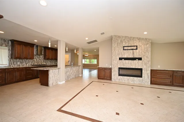 a large white kitchen with a large window and stainless steel appliances