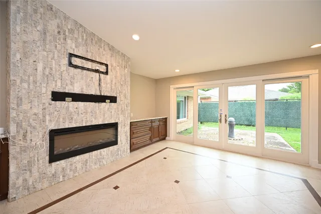 a view of an empty room with a fireplace and a large window