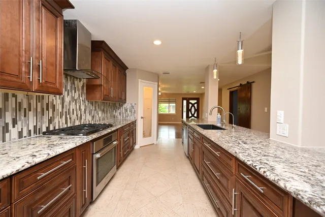 a large kitchen with kitchen island granite countertop a large counter top and wooden cabinets
