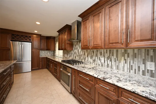 a kitchen with stainless steel appliances granite countertop a refrigerator and a sink
