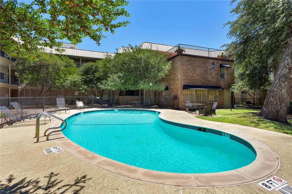 910 Duncan Lane, Unit 35 Austin, TX 78705 - Photo 16 of 20 An inviting community pool beckons, offering a refreshing escape alongside manicured lawns and charming brick architecture.