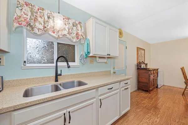 a kitchen with a sink and a wooden floor