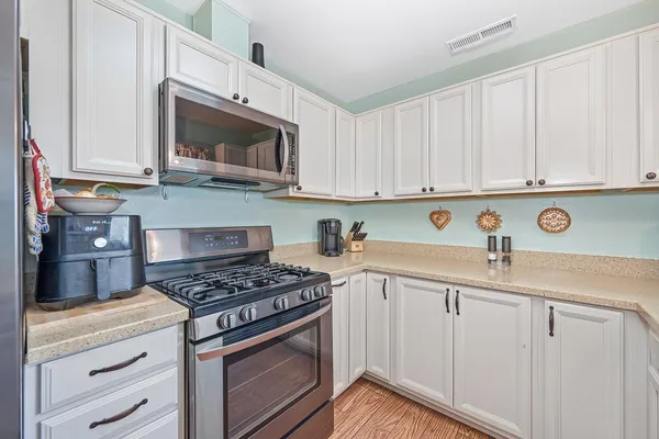 a kitchen with stainless steel appliances granite countertop a stove and a microwave
