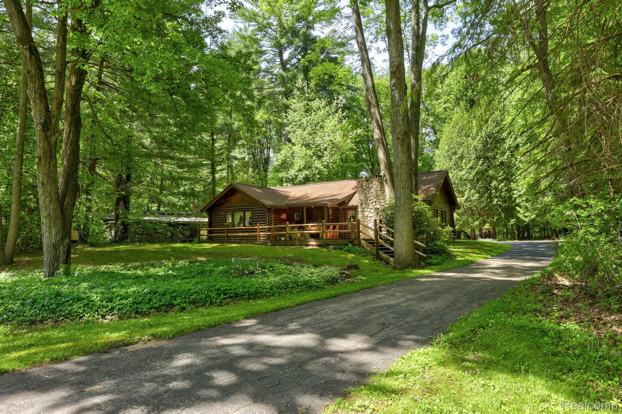 3814 South Towerline Road Bridgeport, MI 48722 - Photo 1 of 52 Log cabin style residence featuring a stone chimney, covered porch with wood railings, and a shingle roof