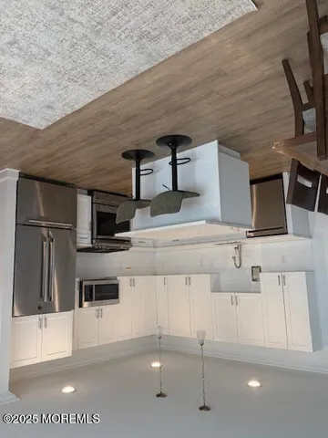 a kitchen with stainless steel appliances kitchen island sink refrigerator and microwave